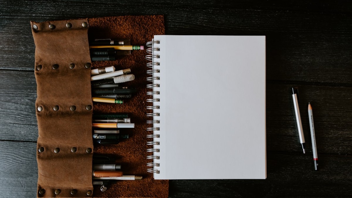 white spiral notebook on brown wooden table