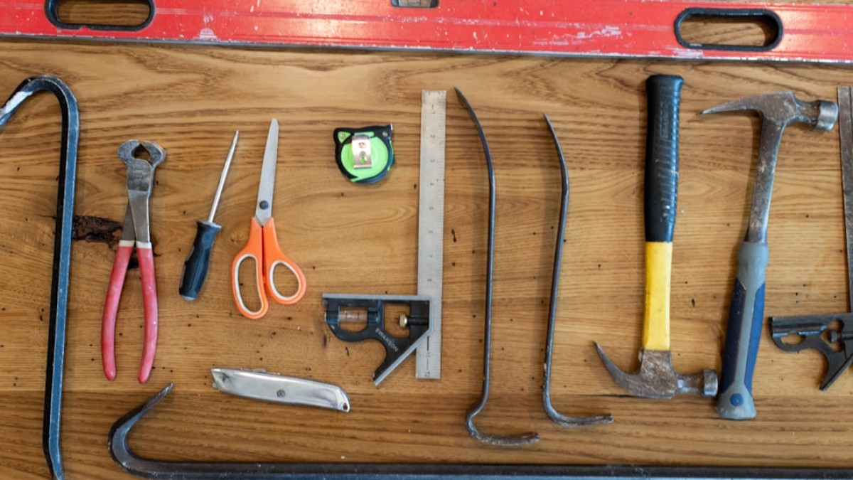 assorted hand tools on brown wooden table